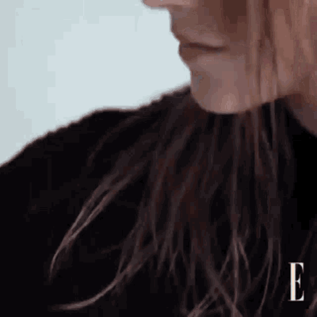 a close up of a woman 's face with the letter e visible in the corner