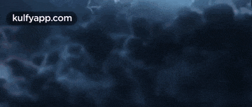 a fireball is flying through a cloudy sky at night