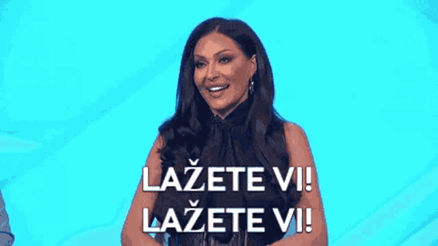 a woman in a black dress is standing in front of a blue background and says lazete vi ! lazete vi !