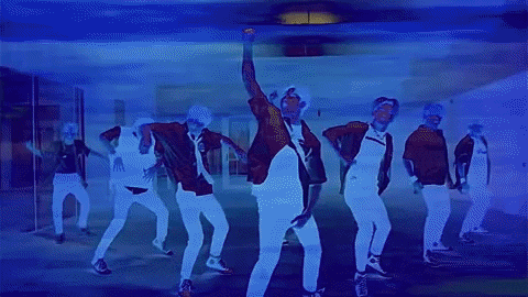 a group of people are dancing in front of a mirror in a room