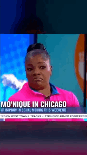 a woman in a pink shirt is being interviewed on a news channel