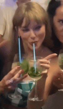 a woman drinking through a straw from a glass