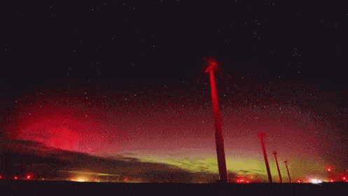 a row of wind turbines against a starry sky