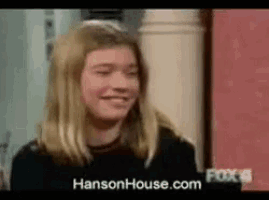 a girl is smiling in front of a sign that says hanson house.com
