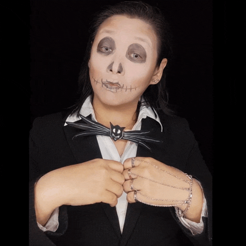 a woman with a skeleton face painted on her face and a cat bow tie