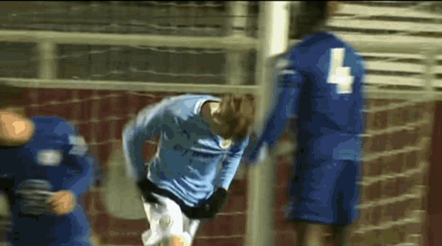 a soccer player in a blue jersey with the number 4 on his back