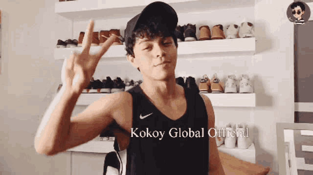 a man wearing a black tank top with kokoy global official written on the bottom