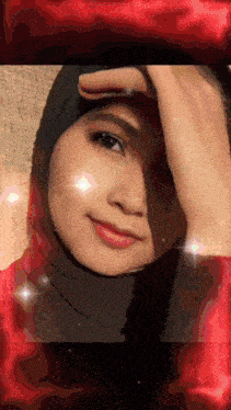 a woman wearing a black hijab is smiling with a red background