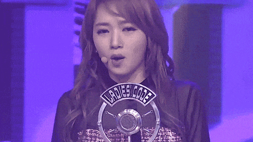 a woman stands in front of a microphone that says " ladies code "