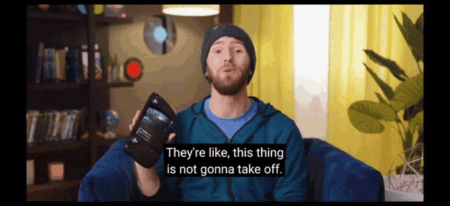 a man sitting on a couch holding a tablet with the words they 're like this thing is not gonna take off