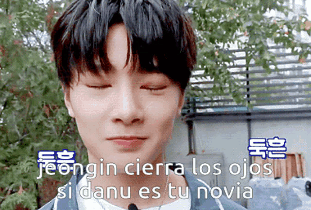 a close up of a person 's face with the words jeongin cierra los ojos si danu es tu novia