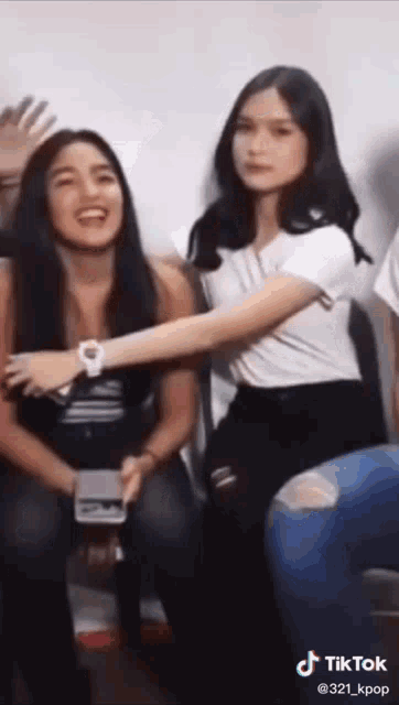two girls are sitting next to each other and one of them is wearing a watch