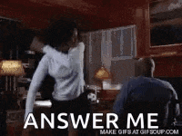 a man and a woman are dancing in a living room and the woman is asking the man to answer her question .