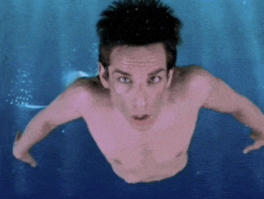 a shirtless man is swimming in a pool