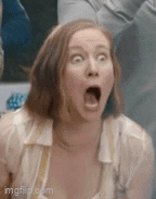 a woman is making a funny face with her mouth open and her eyes closed .