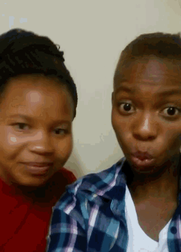 a woman in a plaid shirt is making a funny face next to another woman