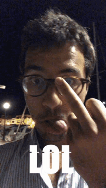 a man wearing glasses is sticking out his tongue and the word lol is on the bottom