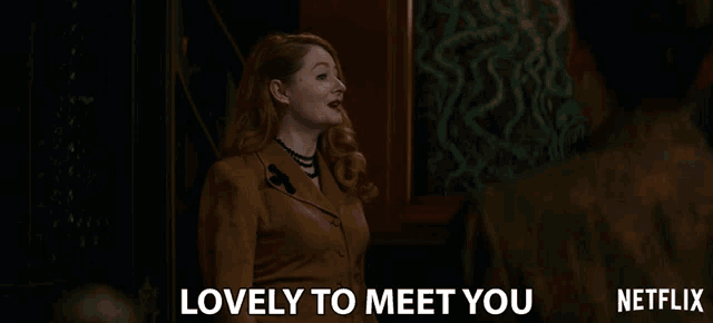 a woman says lovely to meet you in front of a man