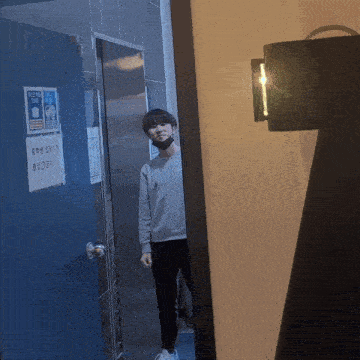 a man wearing a mask is standing in front of a door with a sign on it that says ' a warning '