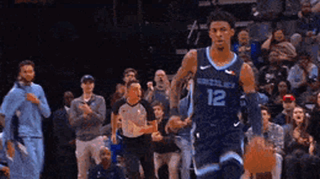 a basketball player with the number 12 on his jersey is running on the court