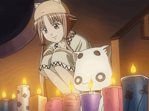 a girl in a cat hat sits next to a cat with candles
