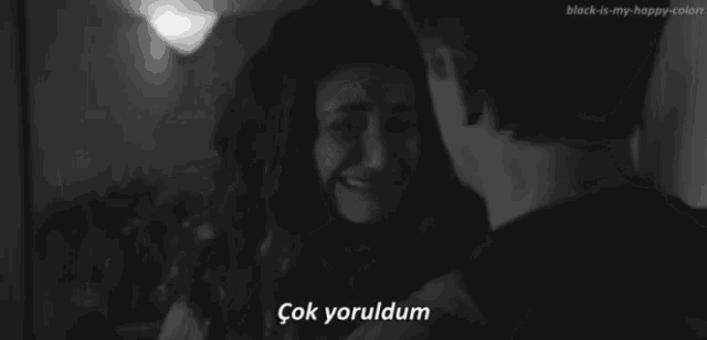 a black and white photo of a man hugging a woman who is crying with a caption that says çok yoruldum