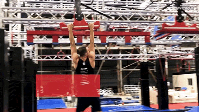 a man is doing a pull up in a gym with a red circle around him that says awesome