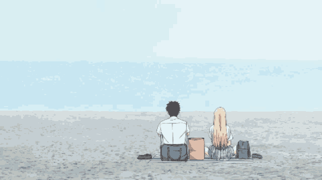 a man and a woman are sitting on the beach looking out to the ocean