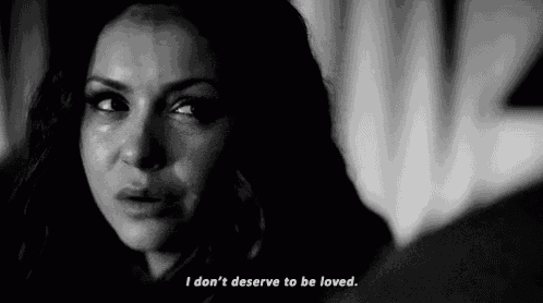 a woman is crying in a black and white photo with the words `` i don t deserve to be loved '' .