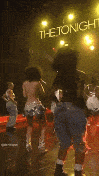 a group of people dancing on a stage with a sign that says the tonight