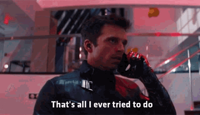a man in a superhero costume is talking on a cell phone in a building .