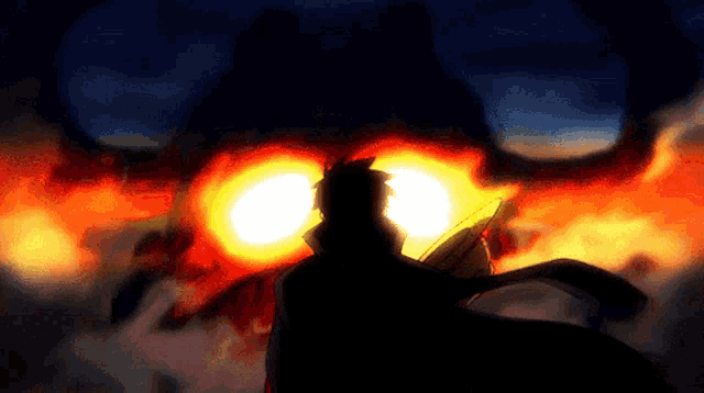 a silhouette of a person standing in front of a giant fire monster