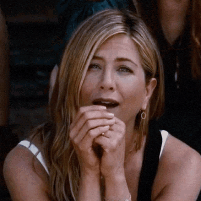 a woman with a ring on her finger is covering her mouth with her hands