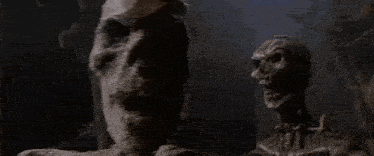 a couple of zombies standing next to each other in a dark room .