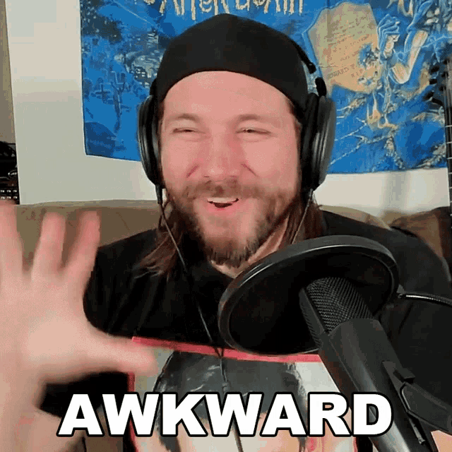 a man wearing headphones and a black hat says awkward