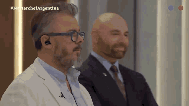 two men are sitting in front of a screen that says masterchefargentina