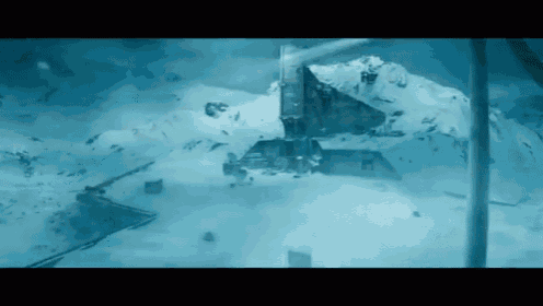 a helicopter is flying over a snow covered mountain in the ocean .
