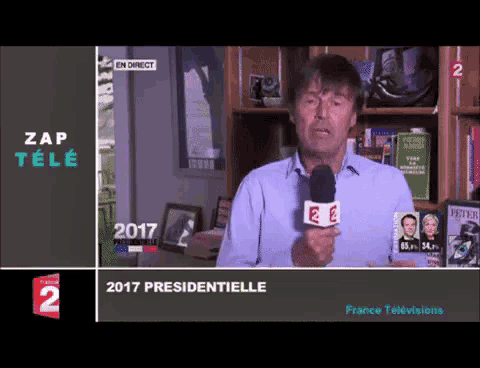 a man holds a microphone in front of a screen that says zap tele 2017 presidentielle