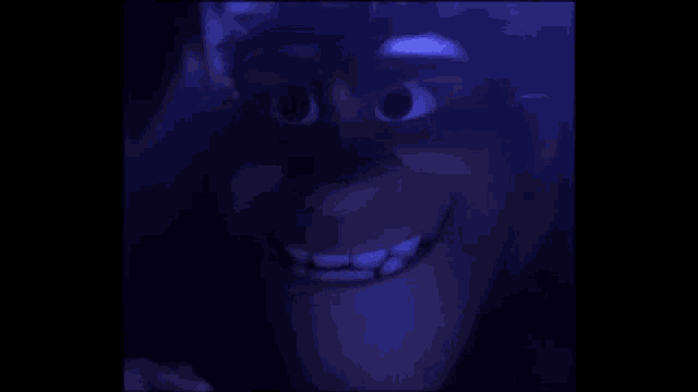 a close up of a cartoon character 's face in the dark with a big smile .