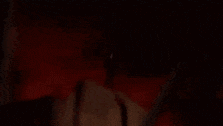 harley quinn is standing in the dark holding a microphone .