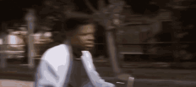 a blurry picture of a man in a white jacket walking down a street