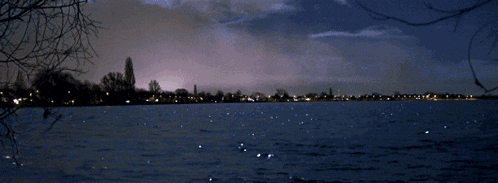 a lake with a city in the distance at night