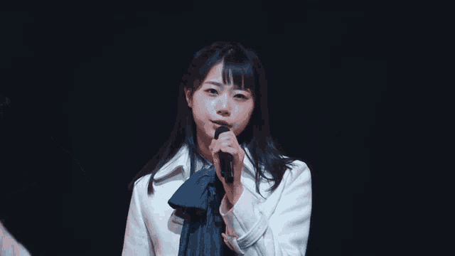 a girl singing into a microphone on stage