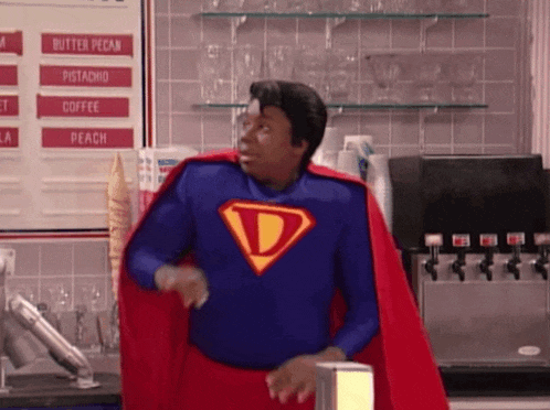 a man in a superhero costume is standing in front of a menu .