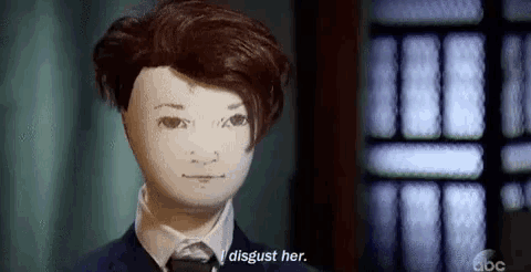a doll is wearing a suit and tie and has a white mask on his face .