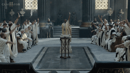 a group of people are gathered in a room with the word gladiator on the wall