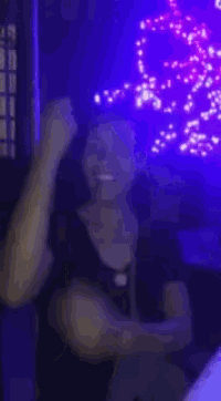 a person is giving the middle finger in front of a purple background .