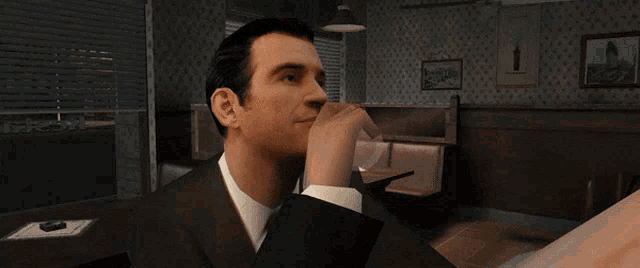 a man in a suit is drinking from a glass