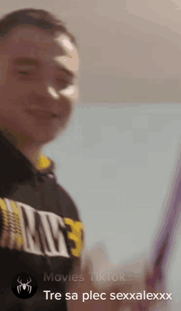 a man wearing a hoodie that says movies tiktok is smiling