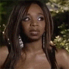 a woman with long brown hair and earrings is making a funny face .